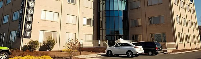Exterior view of an office building with a sign that says