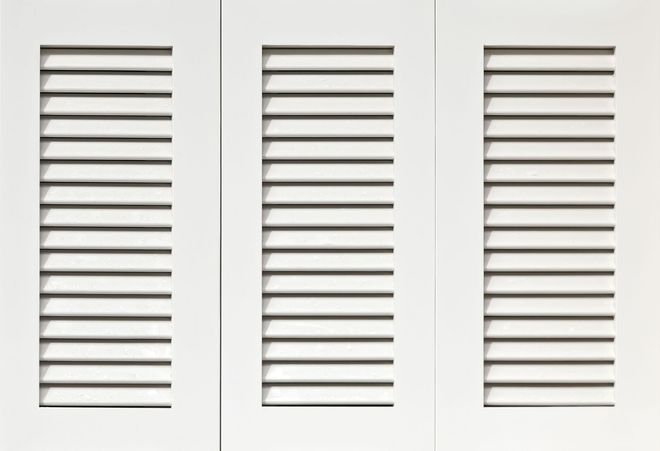 Three white louvered shutters arranged side-by-side.