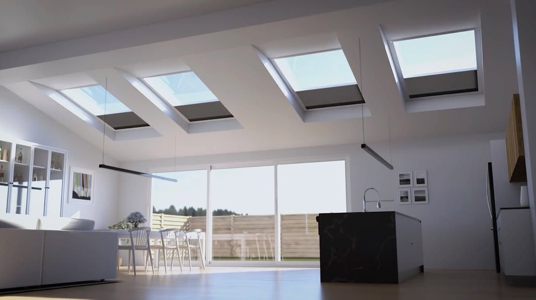 Bright, modern living room with skylights, large windows, and a black kitchen island.