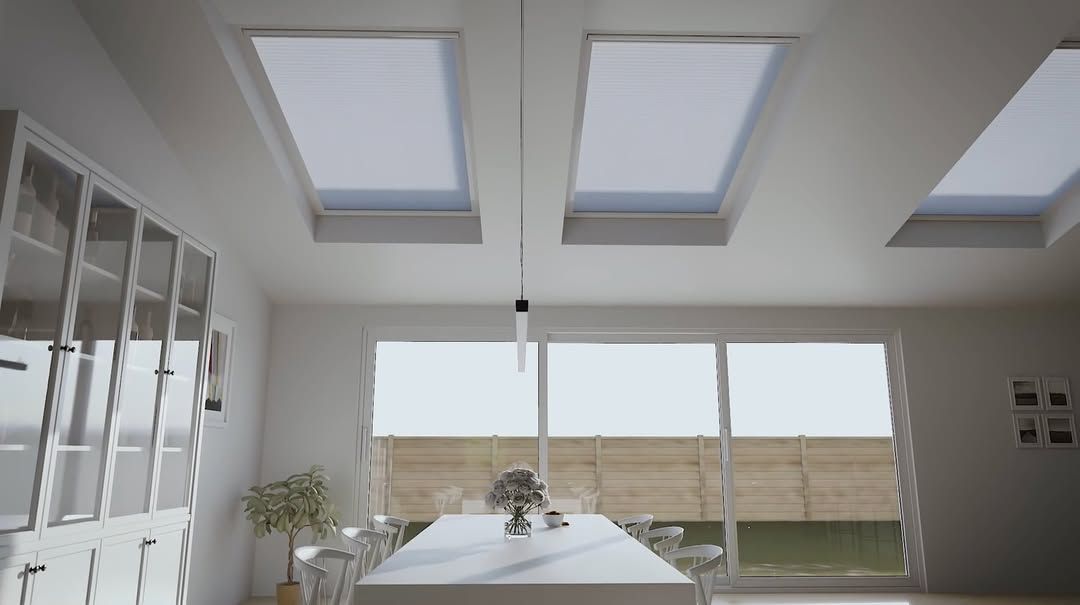 Bright dining room with skylights, long table, glass cabinets, and large windows.