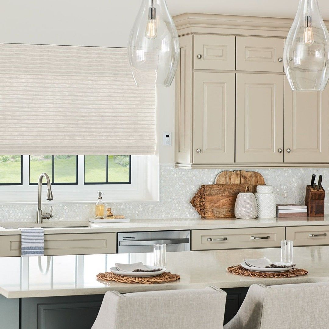 Kitchen with light-colored cabinets, white backsplash, and a breakfast bar with two place settings.