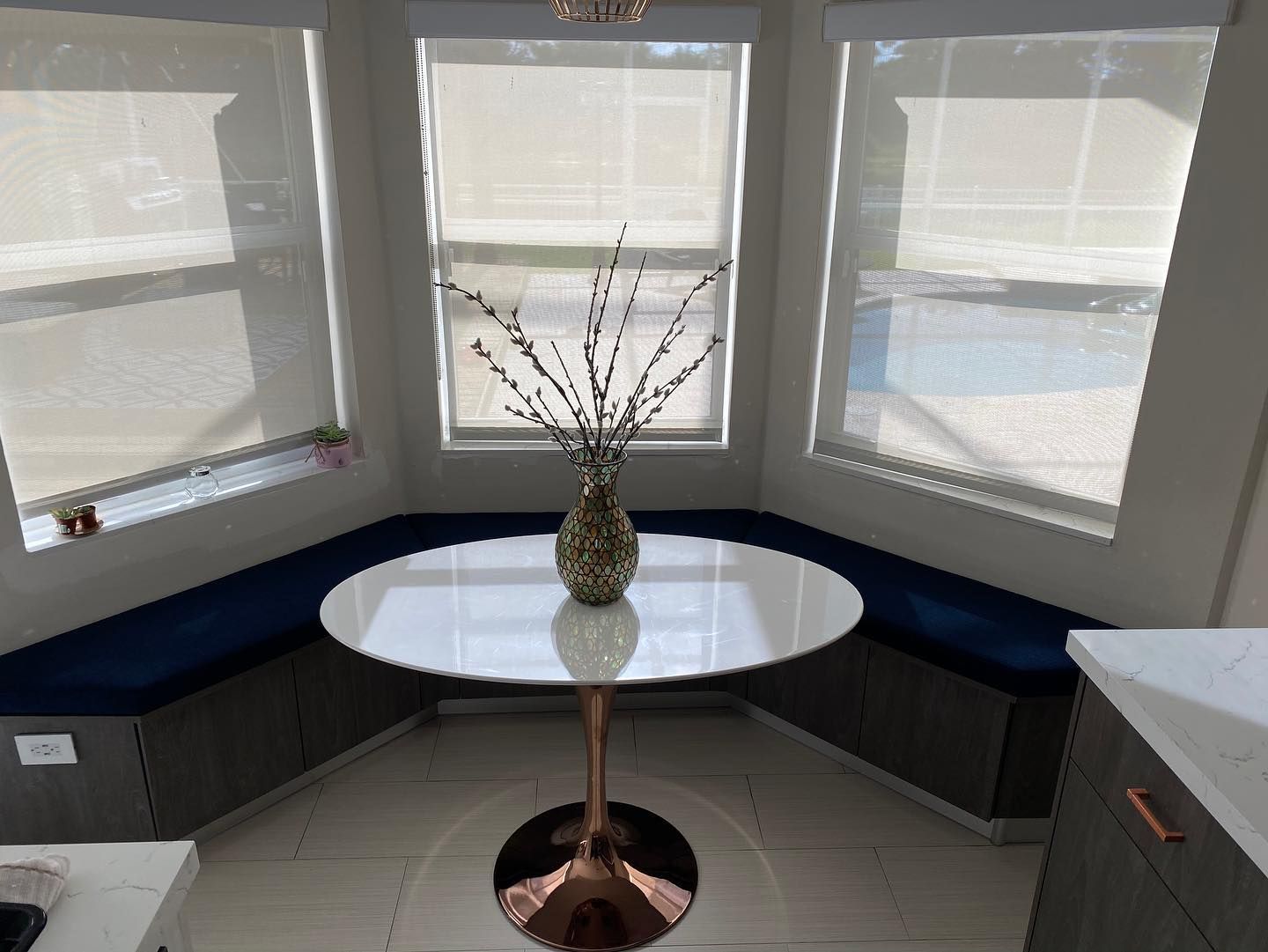 A white table with a vase of flowers on it in a kitchen.