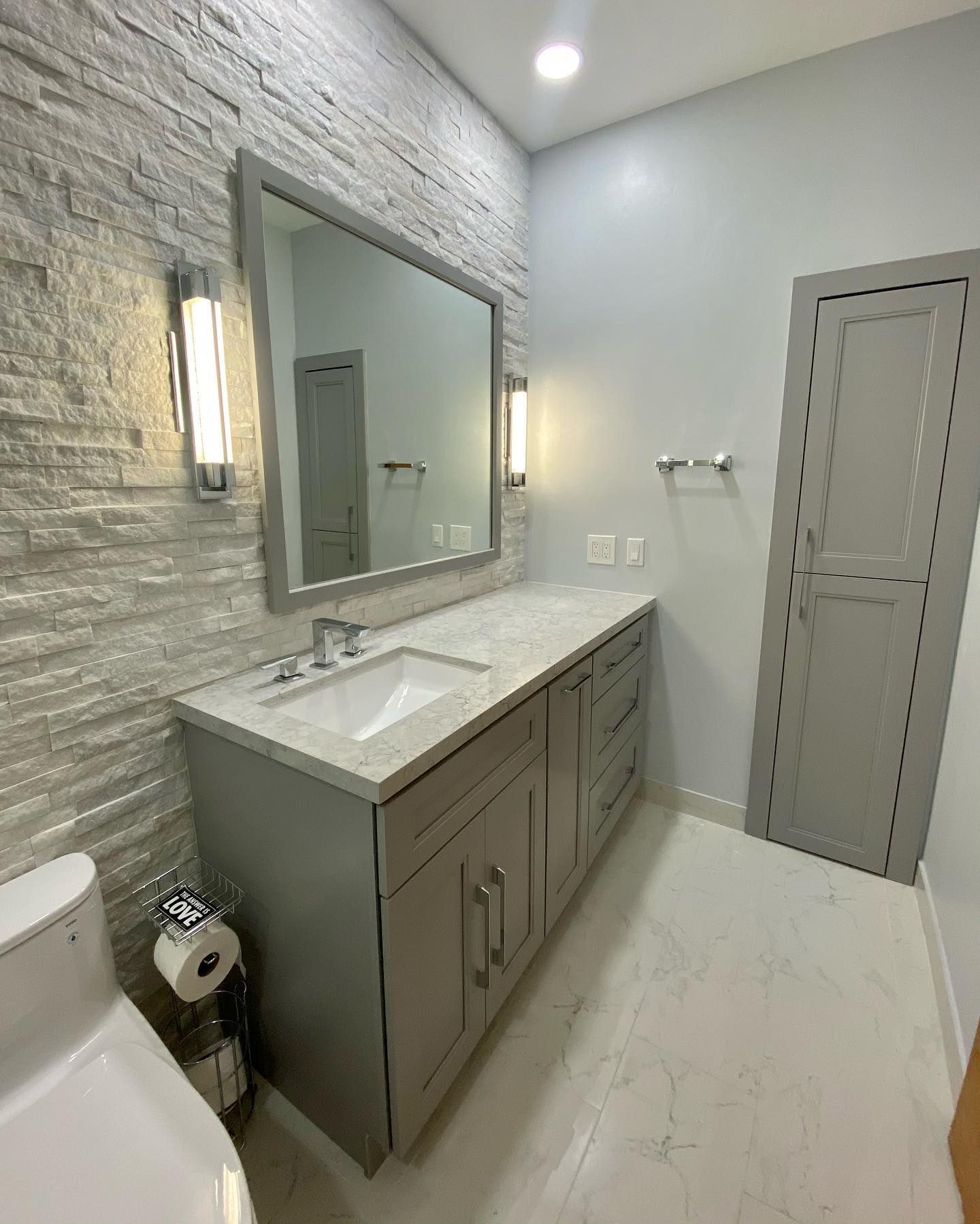 A bathroom with a sink , mirror and toilet.