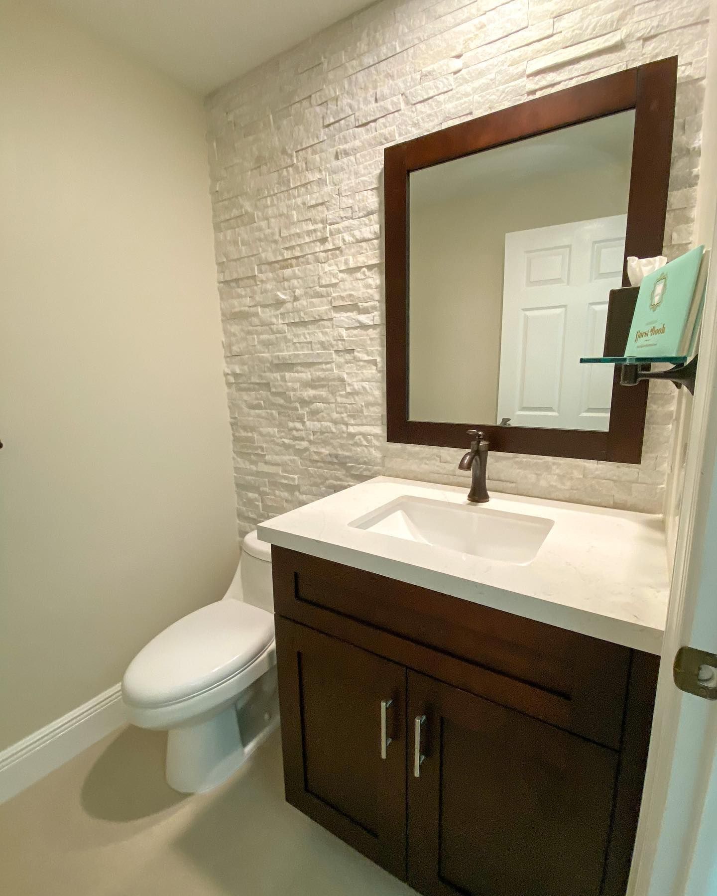 A bathroom with a toilet , sink and mirror