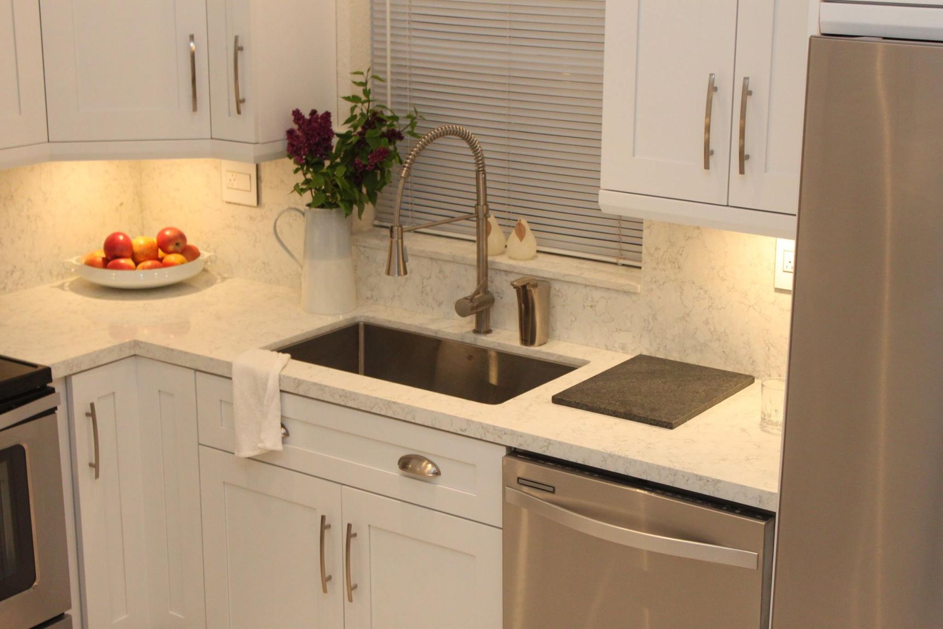 A kitchen with white cabinets and stainless steel appliances