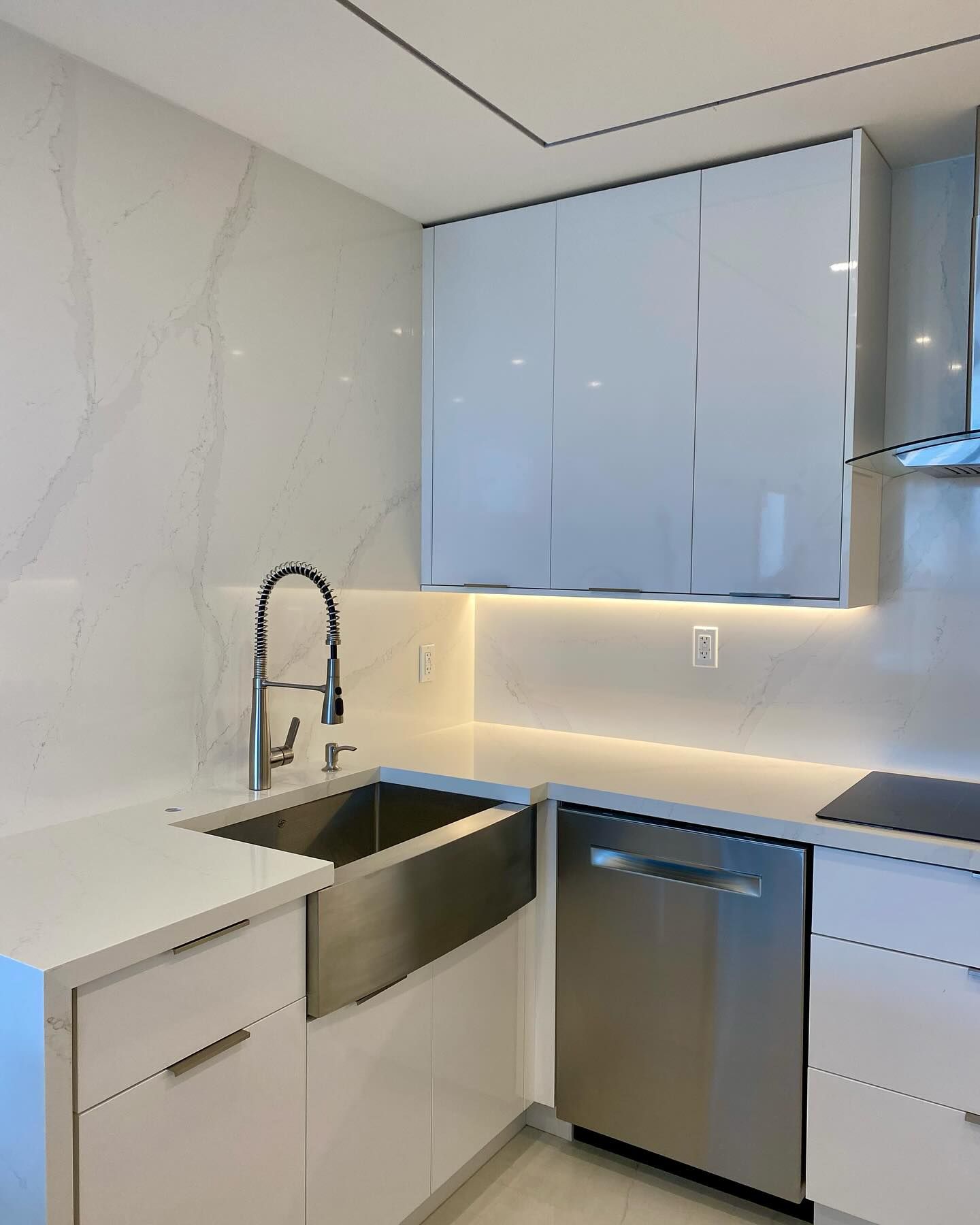 A kitchen with white cabinets and stainless steel appliances