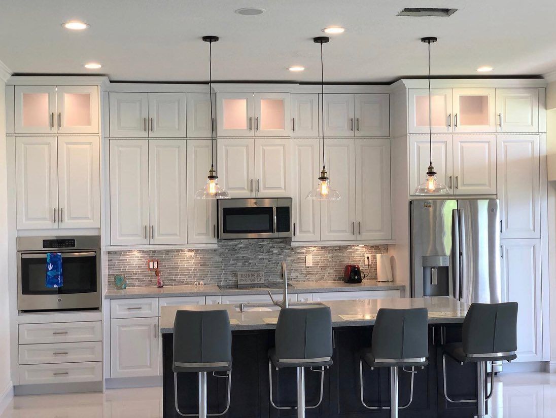 A kitchen with white cabinets and stainless steel appliances
