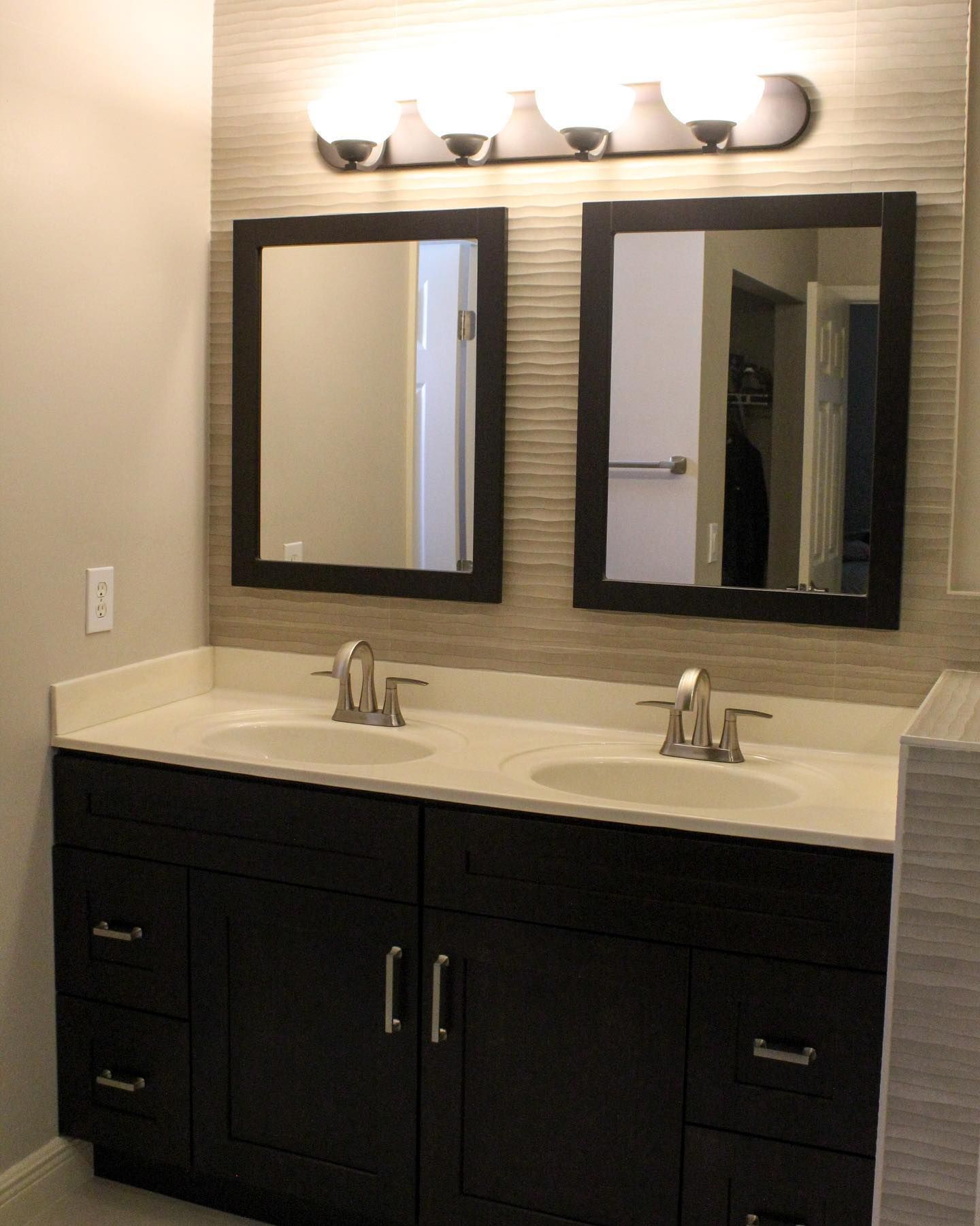 A bathroom with two sinks and two mirrors