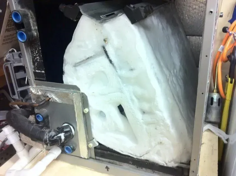 White foam block secured in a metal frame with bolts and wires inside a machine enclosure