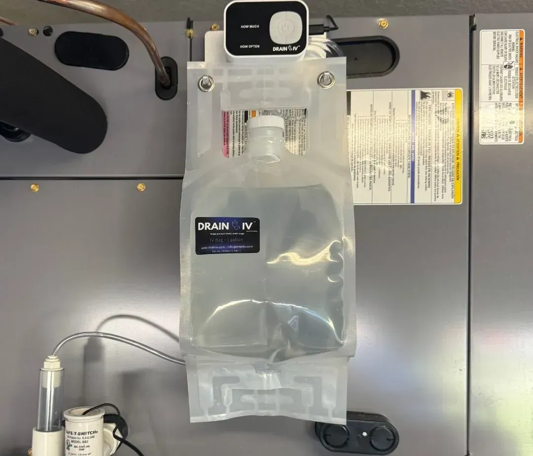 Clear IV fluid bag hanging from a hospital infusion pump with tubing attached.