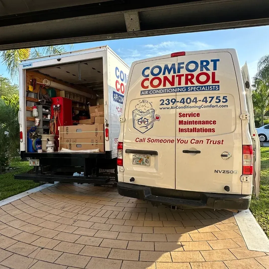 Open service van with boxes and equipment beside a Comfort Control truck in a driveway