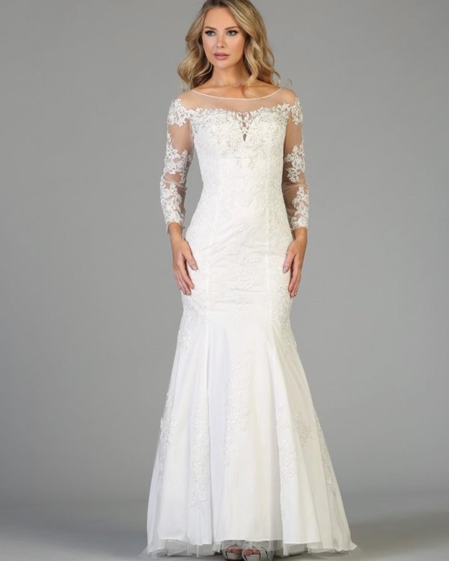 Woman in a white lace mermaid wedding dress with long sleeves.