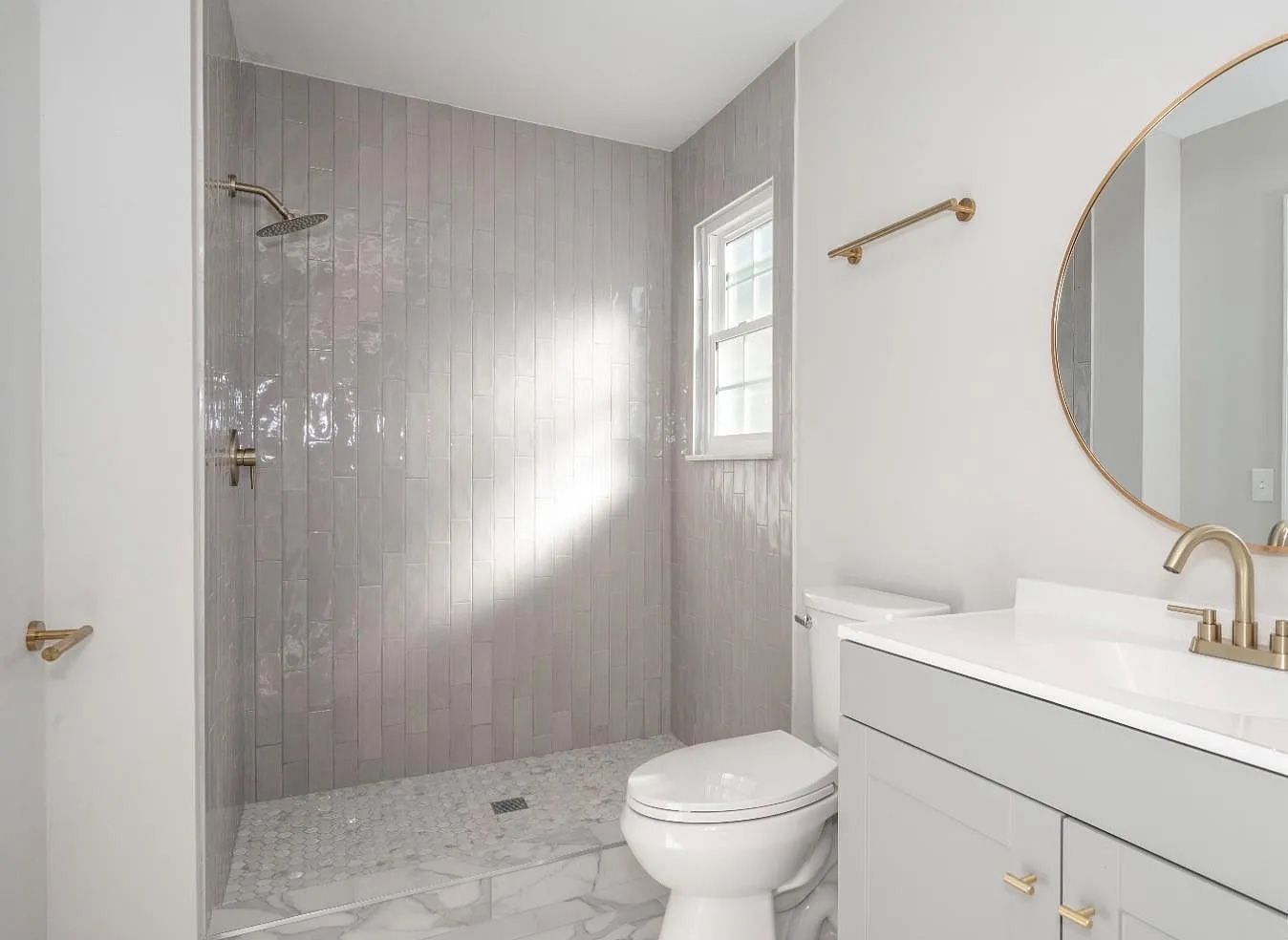 A bathroom with a toilet , sink , shower and mirror.