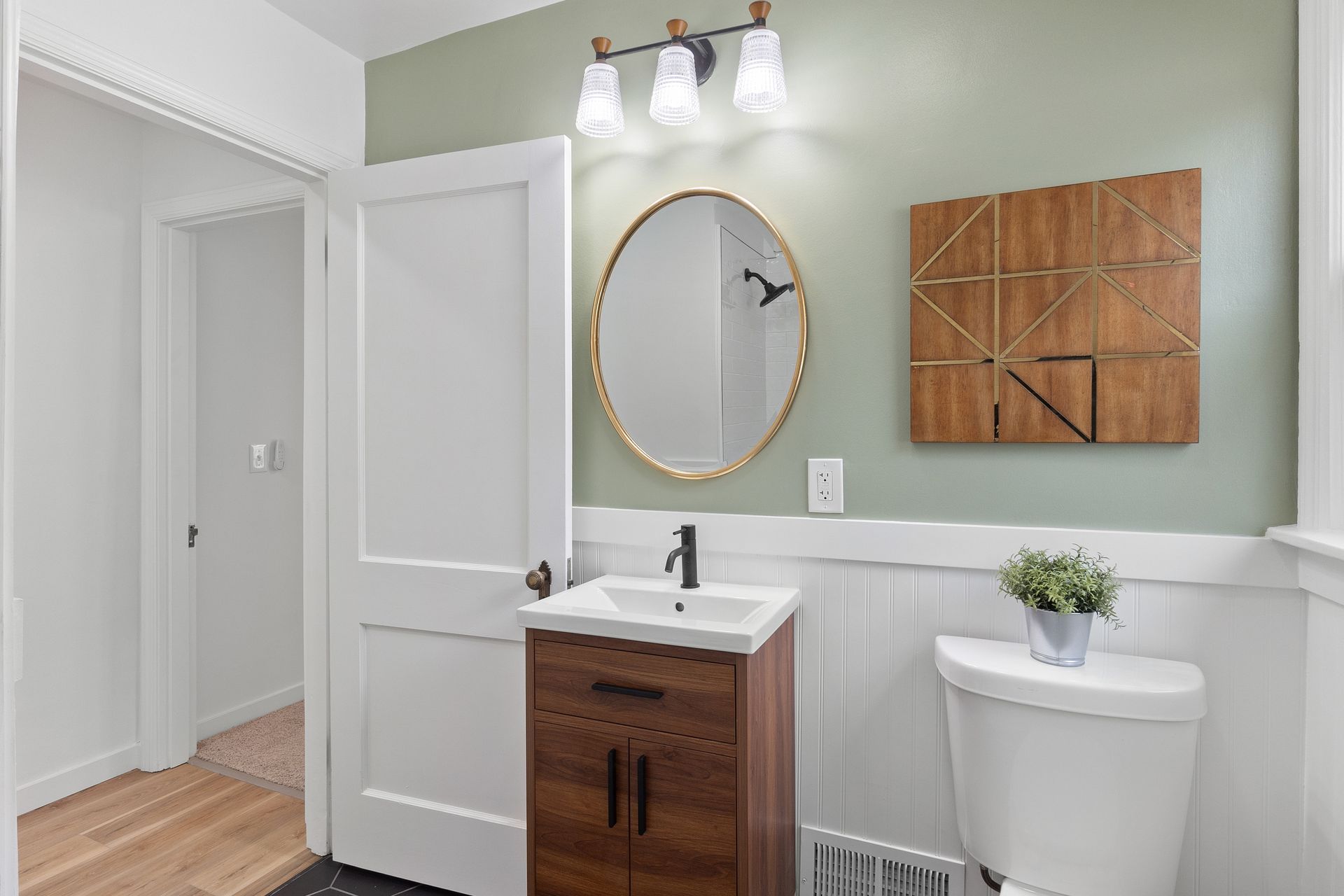A bathroom with a sink , toilet and mirror.
