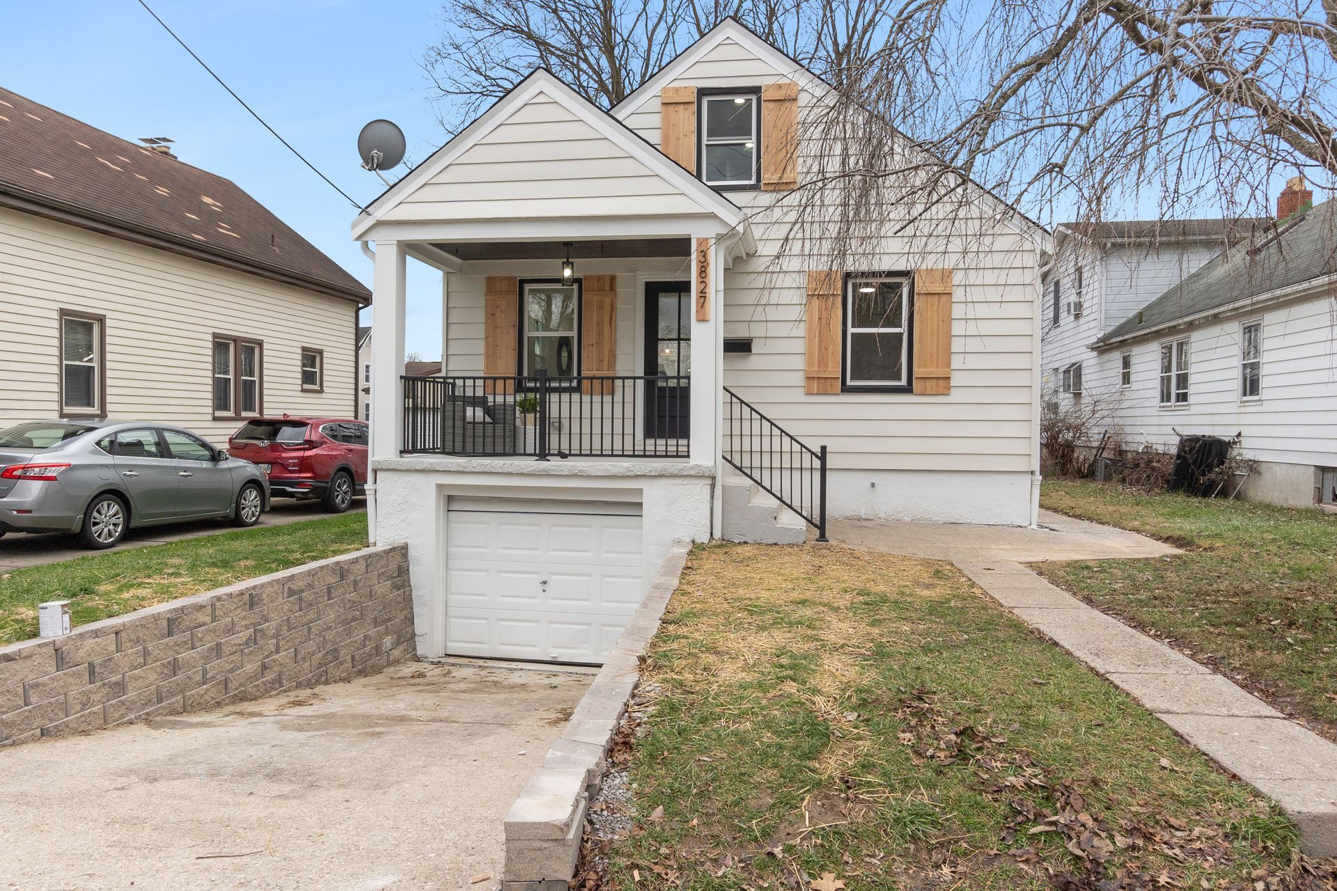 A small white house with a car parked in front of it.