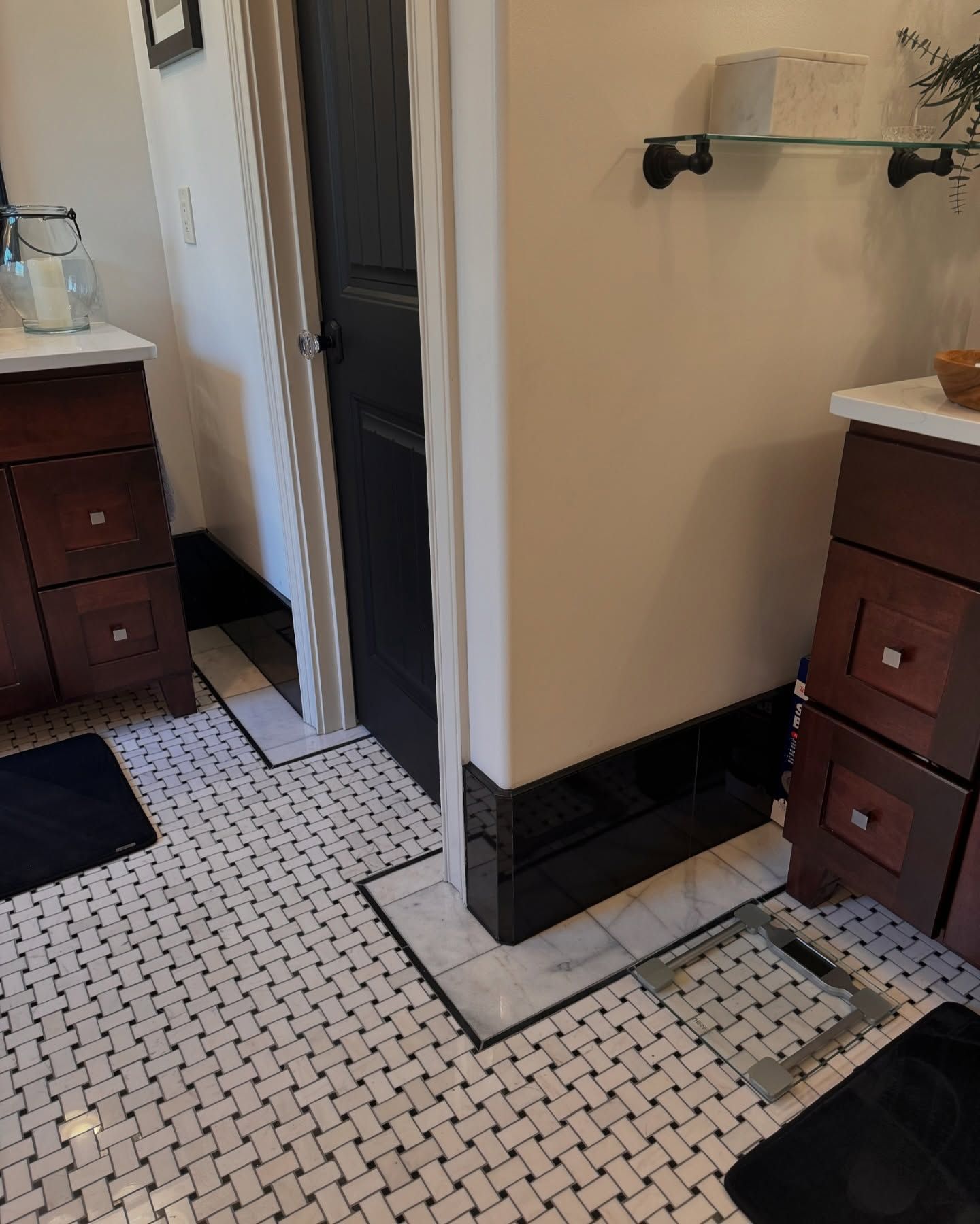Bathroom with dark wood vanities, black trim, white tile floor, and a black door.