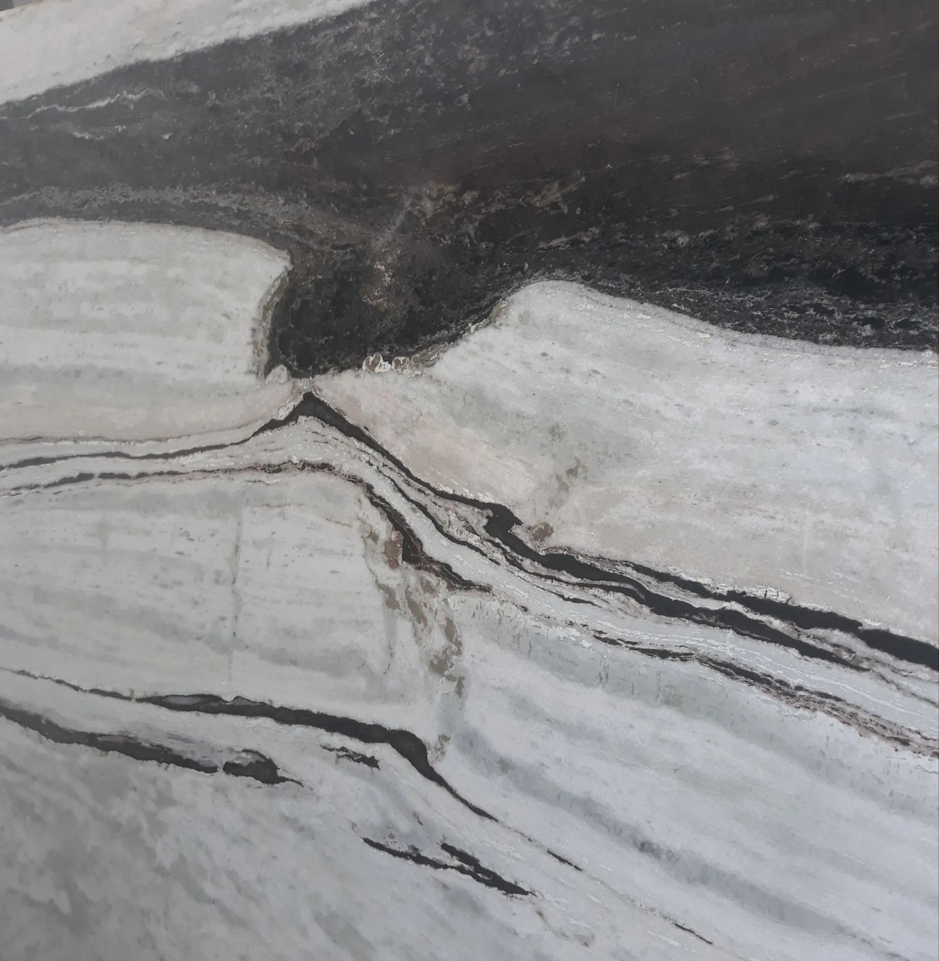 Abstract black, white, and gray marble-like stone pattern with flowing diagonal veins