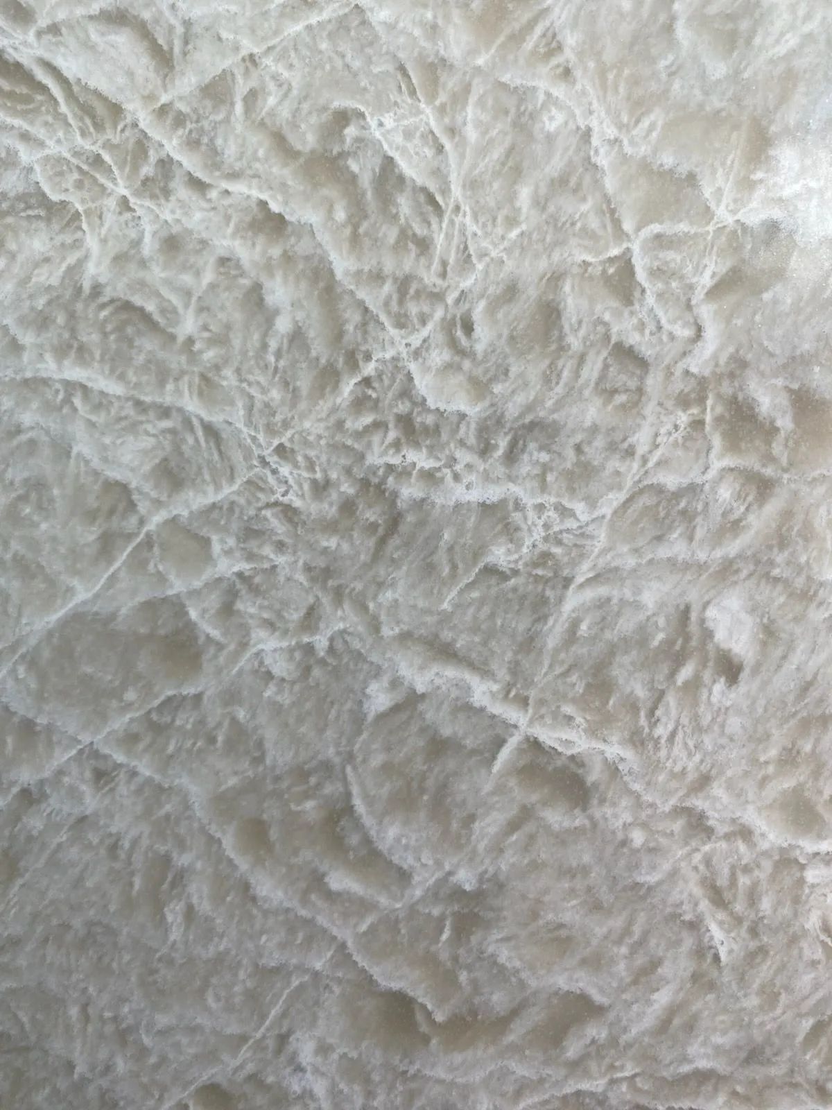Close-up of a white, crumpled textured surface with fine wrinkles and ridges