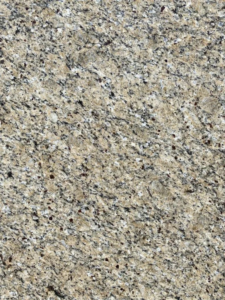 Close-up of a speckled beige and gray stone surface with a rough texture