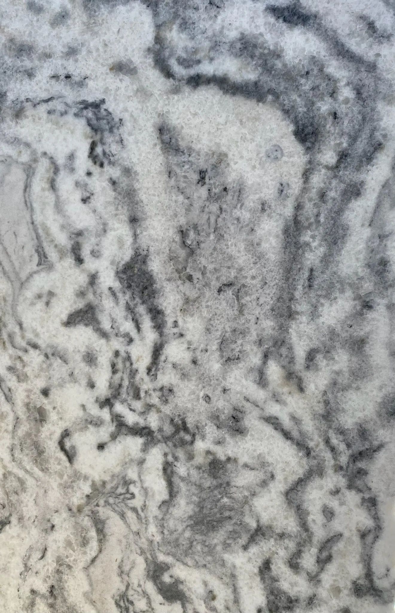 Gray and white marbled stone surface with swirling, wavy patterns