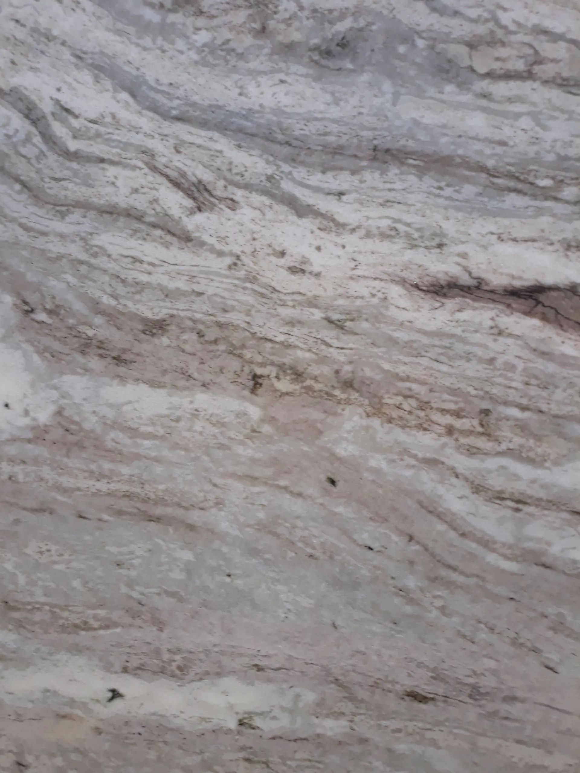 Close-up of gray and white marbled stone with layered veins and subtle brown streaks
