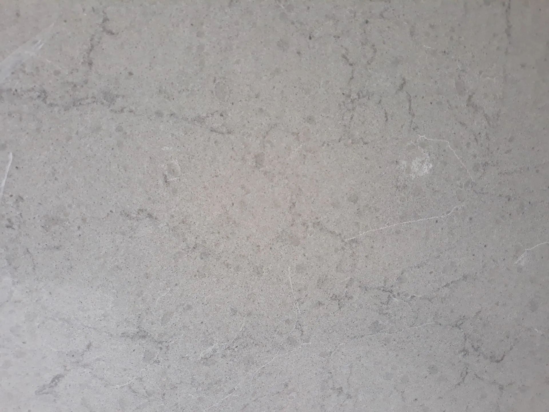 Light gray textured concrete surface with faint speckled marks