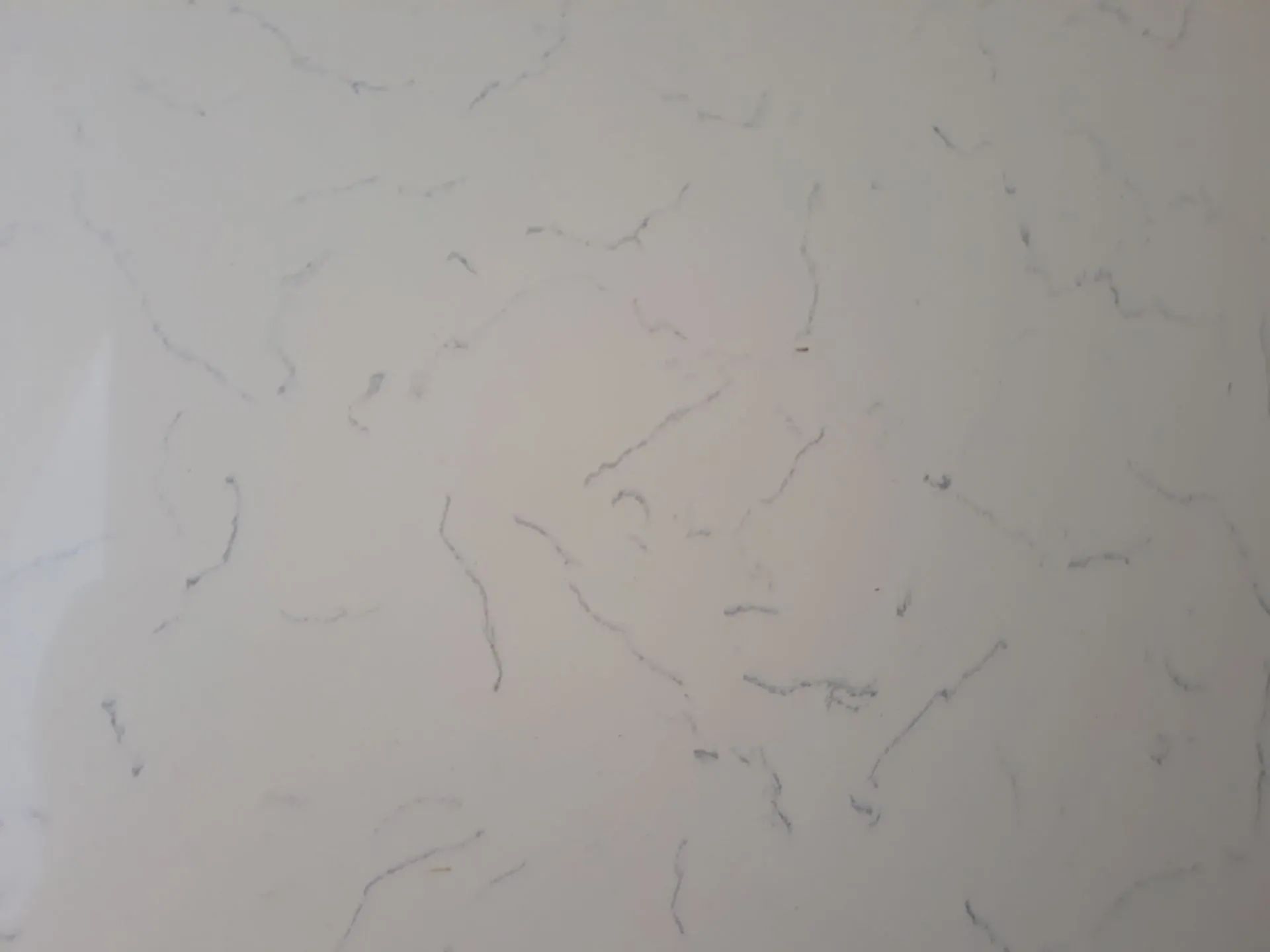 Close-up of a light beige textured wall with subtle gray marbling patterns