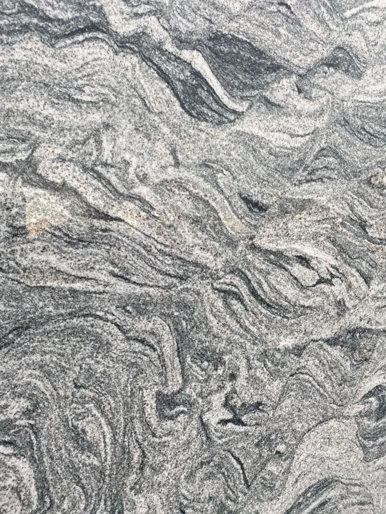 Gray, swirling marble-like stone texture with layered wavy veins