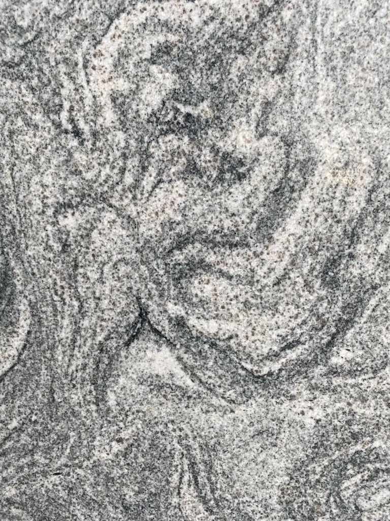 Gray and white swirling textured pattern resembling stone or fabric folds