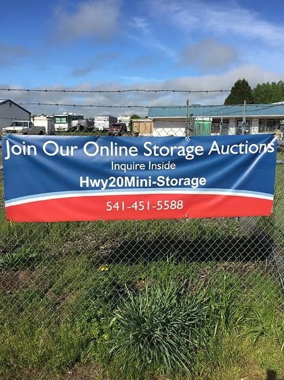 Blue and red banner on fence advertising online storage auctions with phone number and website.