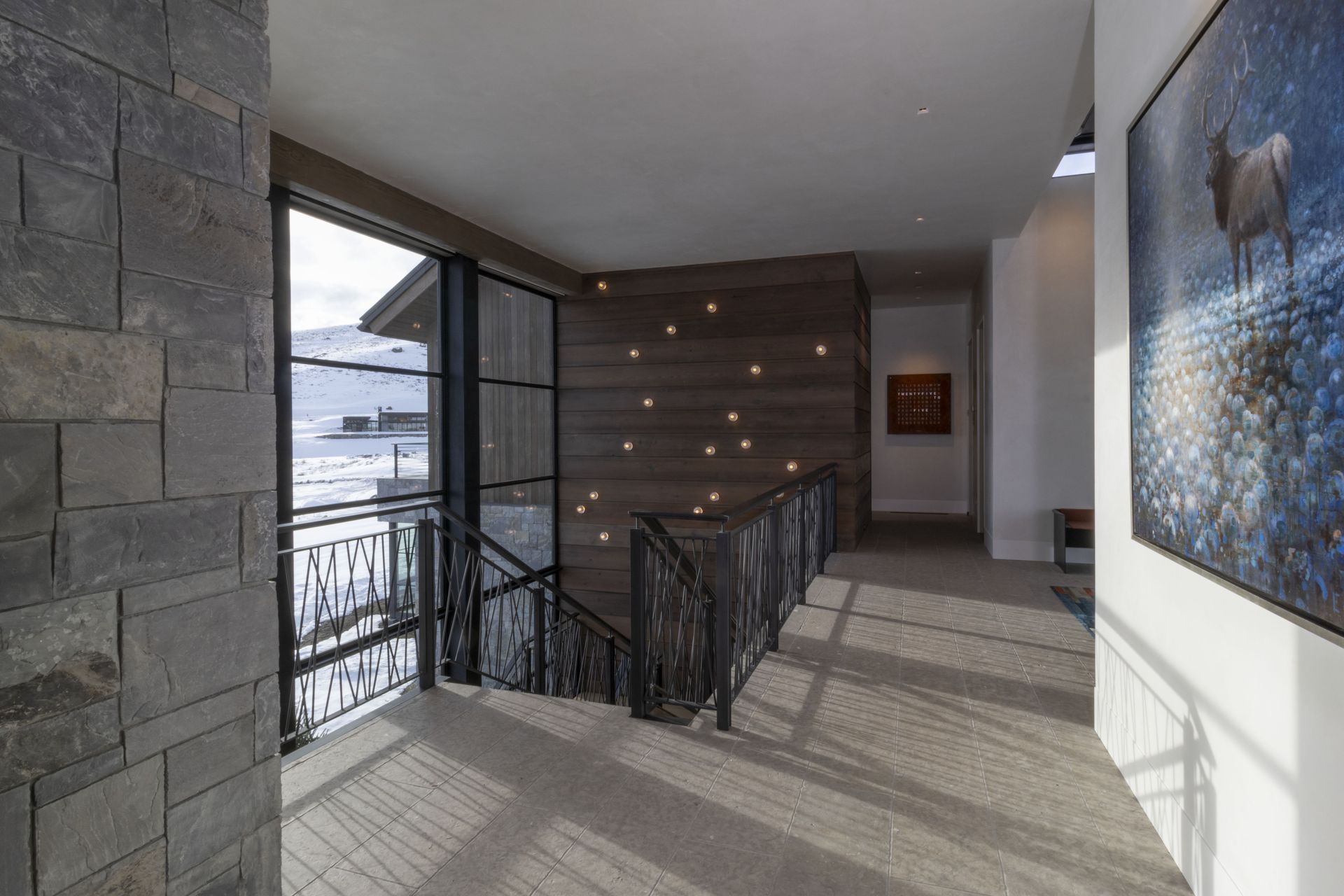 A hallway with a staircase and a painting on the wall