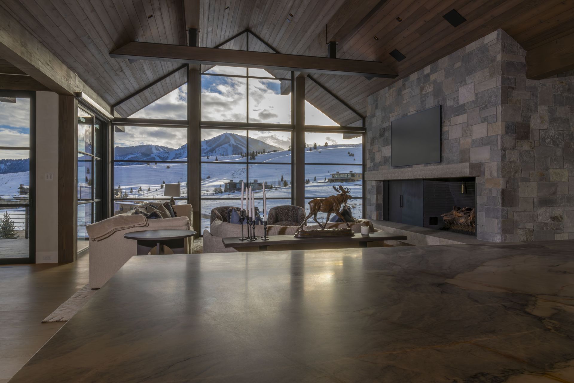 A living room with a fireplace and a view of the mountains