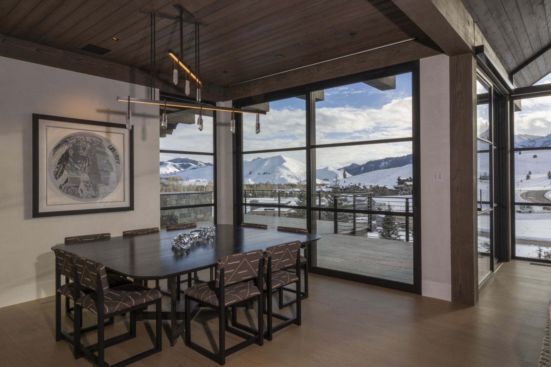 A dining room with a table and chairs and a view of the mountains