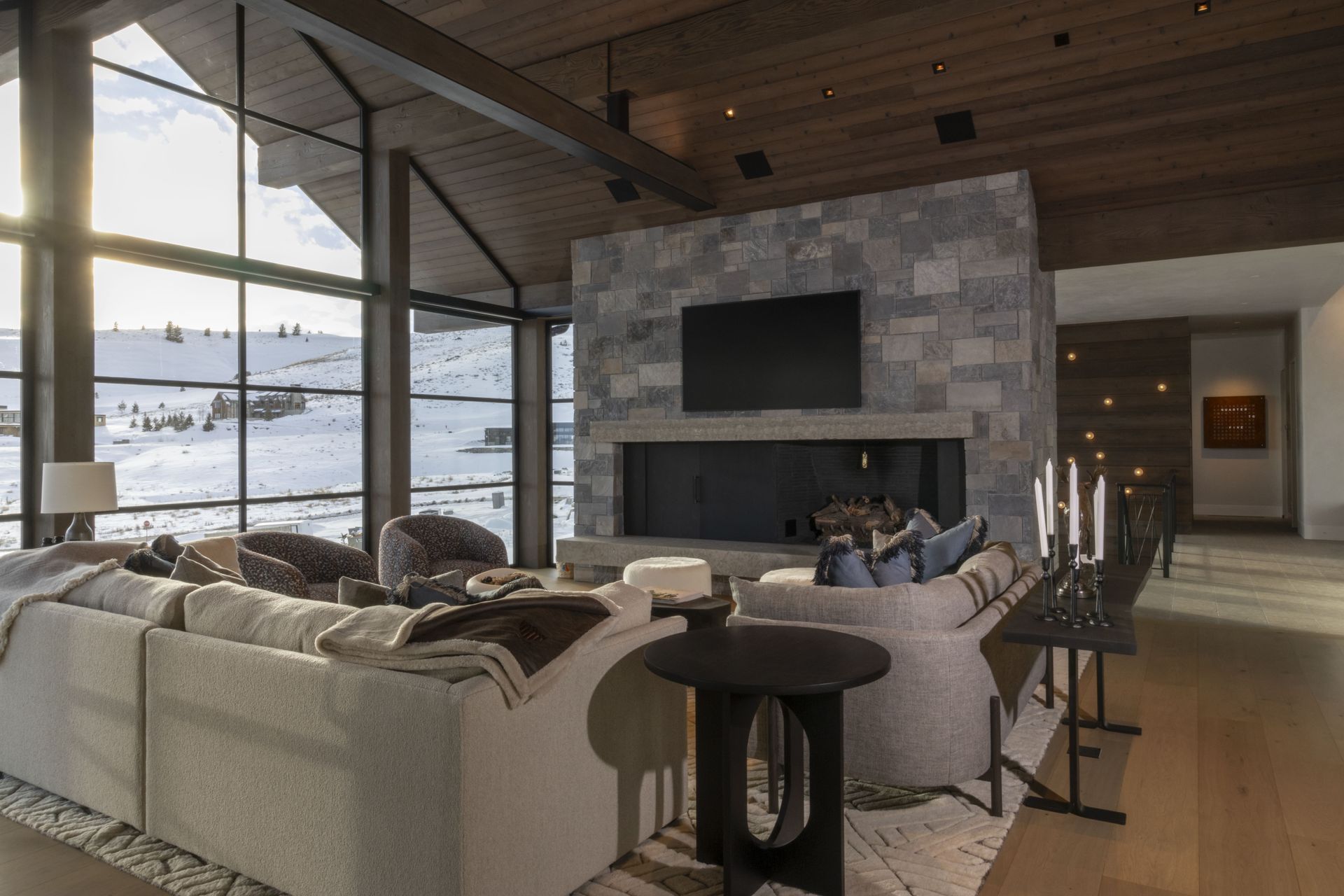 A living room with a fireplace, couch, table and television