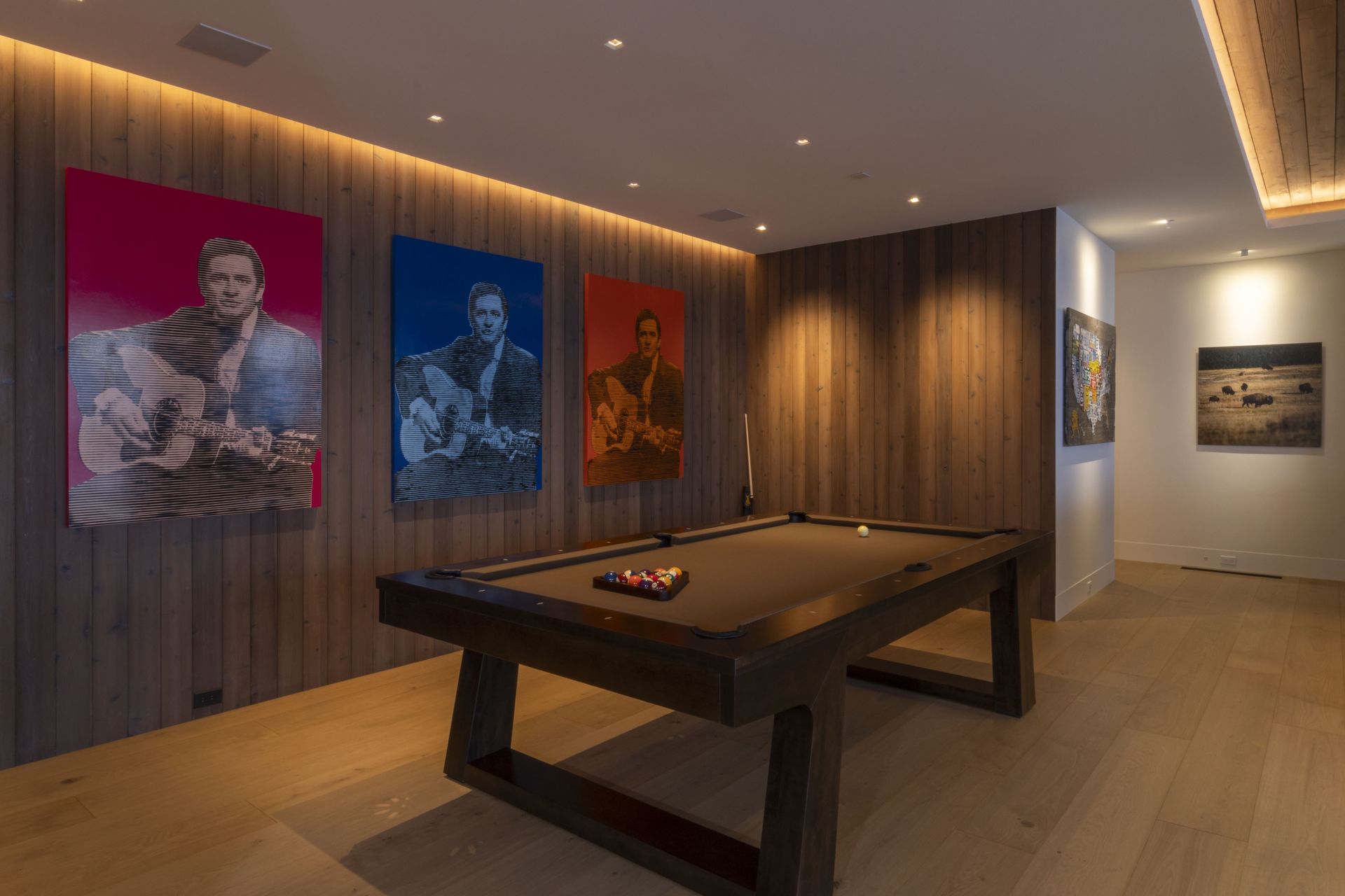 A pool table in a room with paintings on the wall