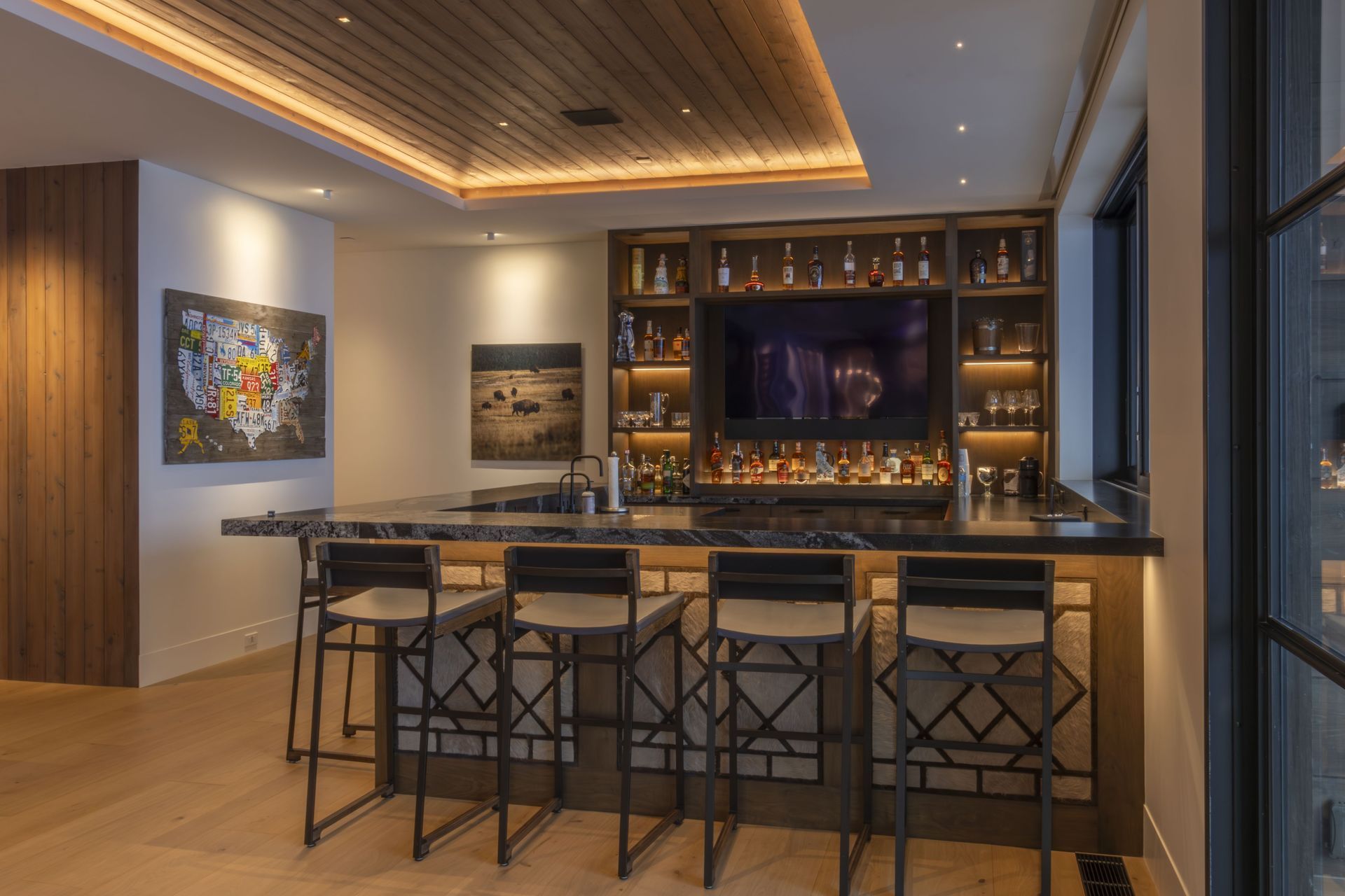 There is a bar in the middle of the room with stools