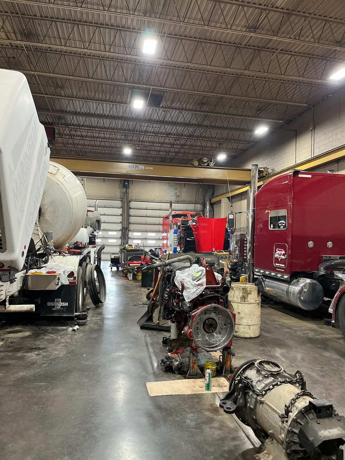 A large warehouse with a lot of trucks in it.