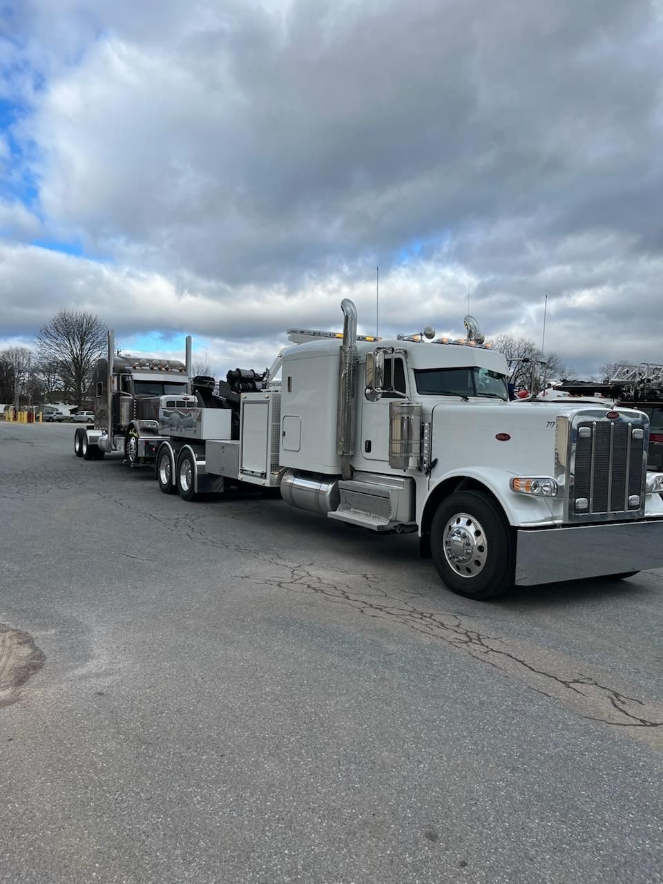 A white semi truck is parked on the side of the road