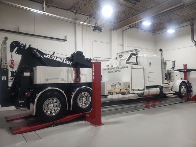 A tow truck is sitting on a lift in a garage.