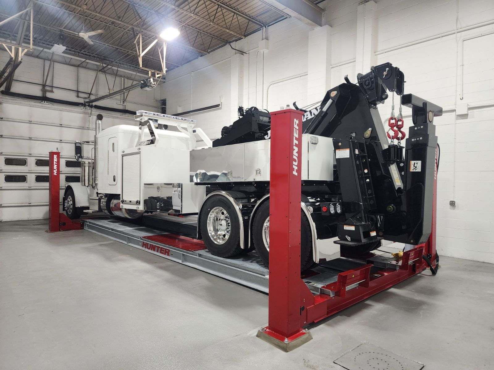 A tow truck is sitting on a lift in a garage.