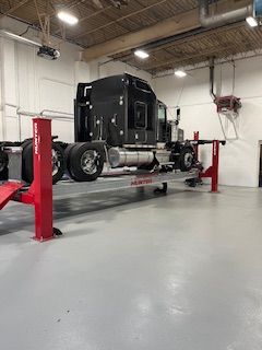 a semi-truck is sitting on a lift in a garage