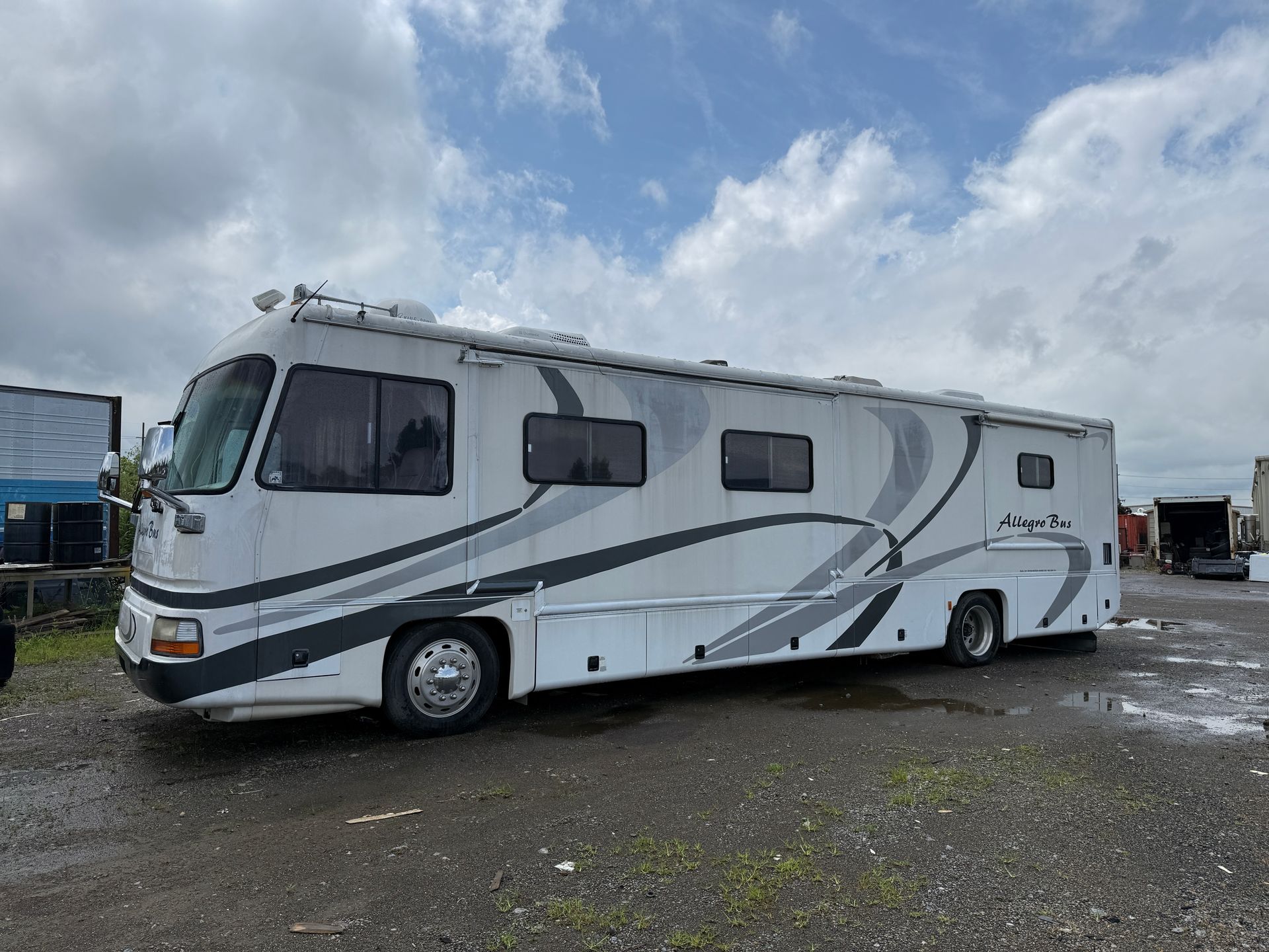 White motorhome parked on a gravel lot under a cloudy sky