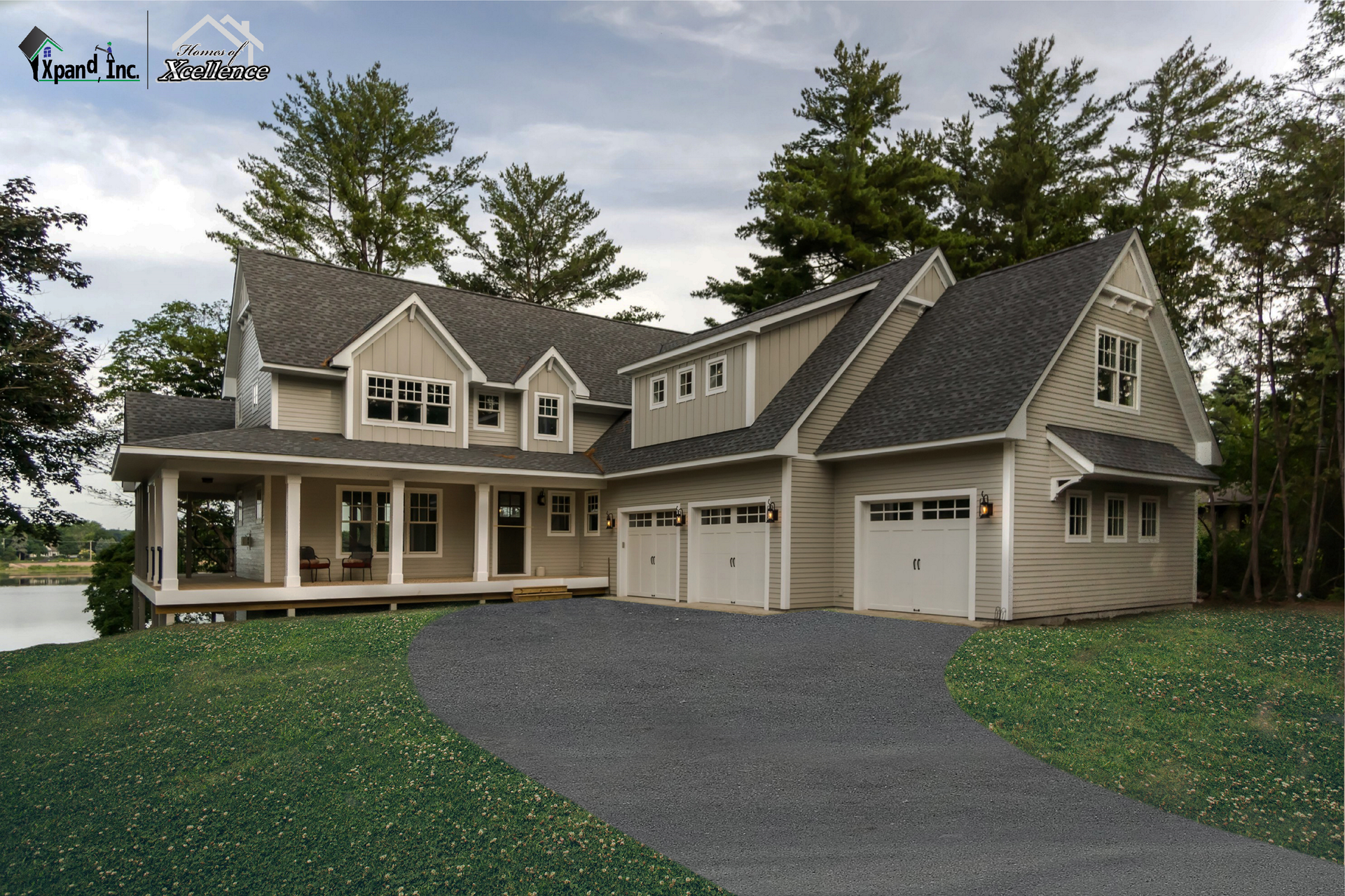 Beige two-story house with porch and three-car garage, gray roof, on a dirt lot near trees.