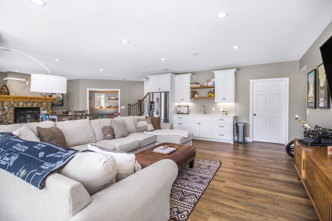 Spacious living room with sectional sofa, kitchenette, fireplace, and wood floors.