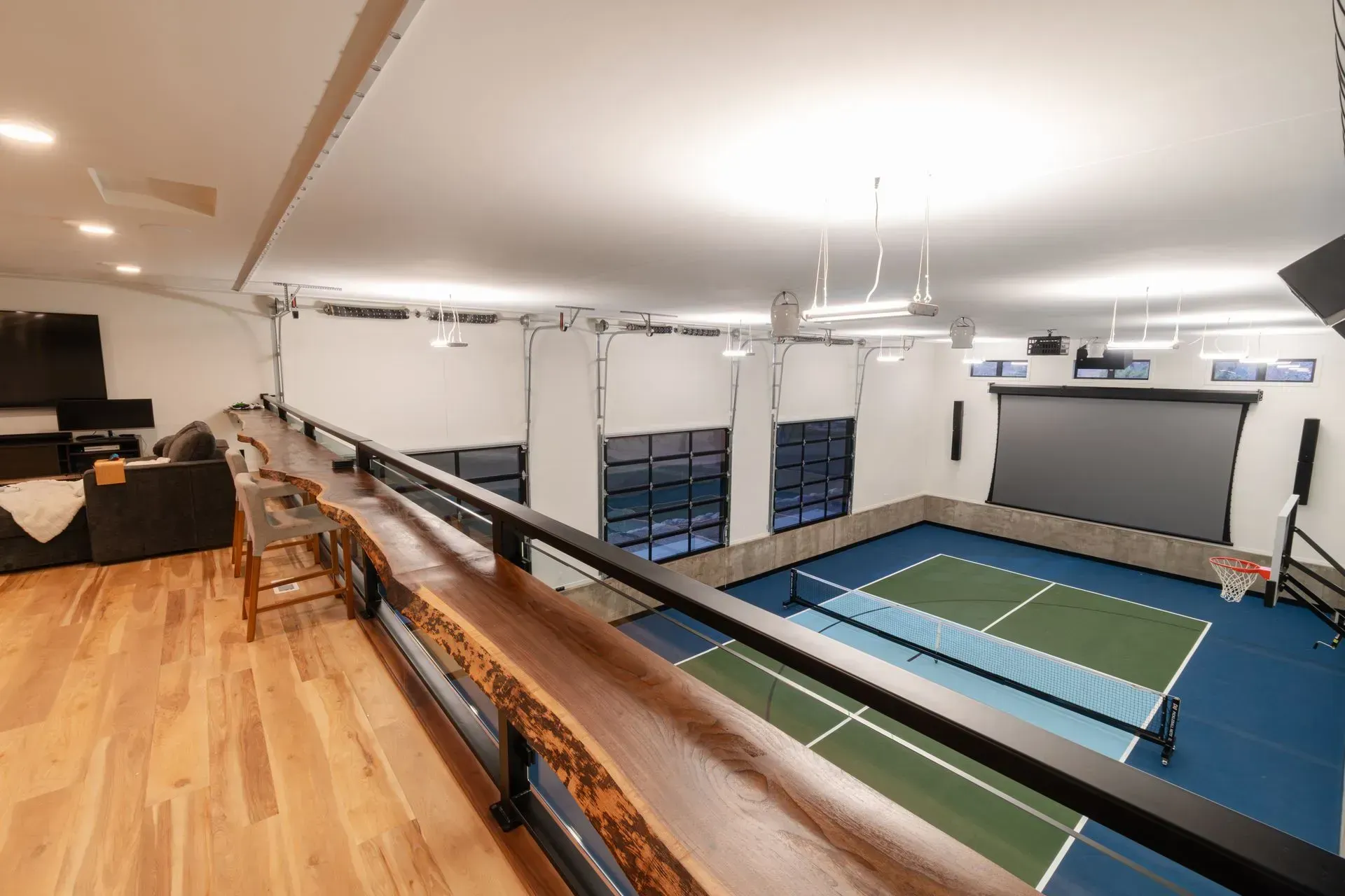 Interior view of a large multi-purpose room with a basketball court, bar, and seating area.