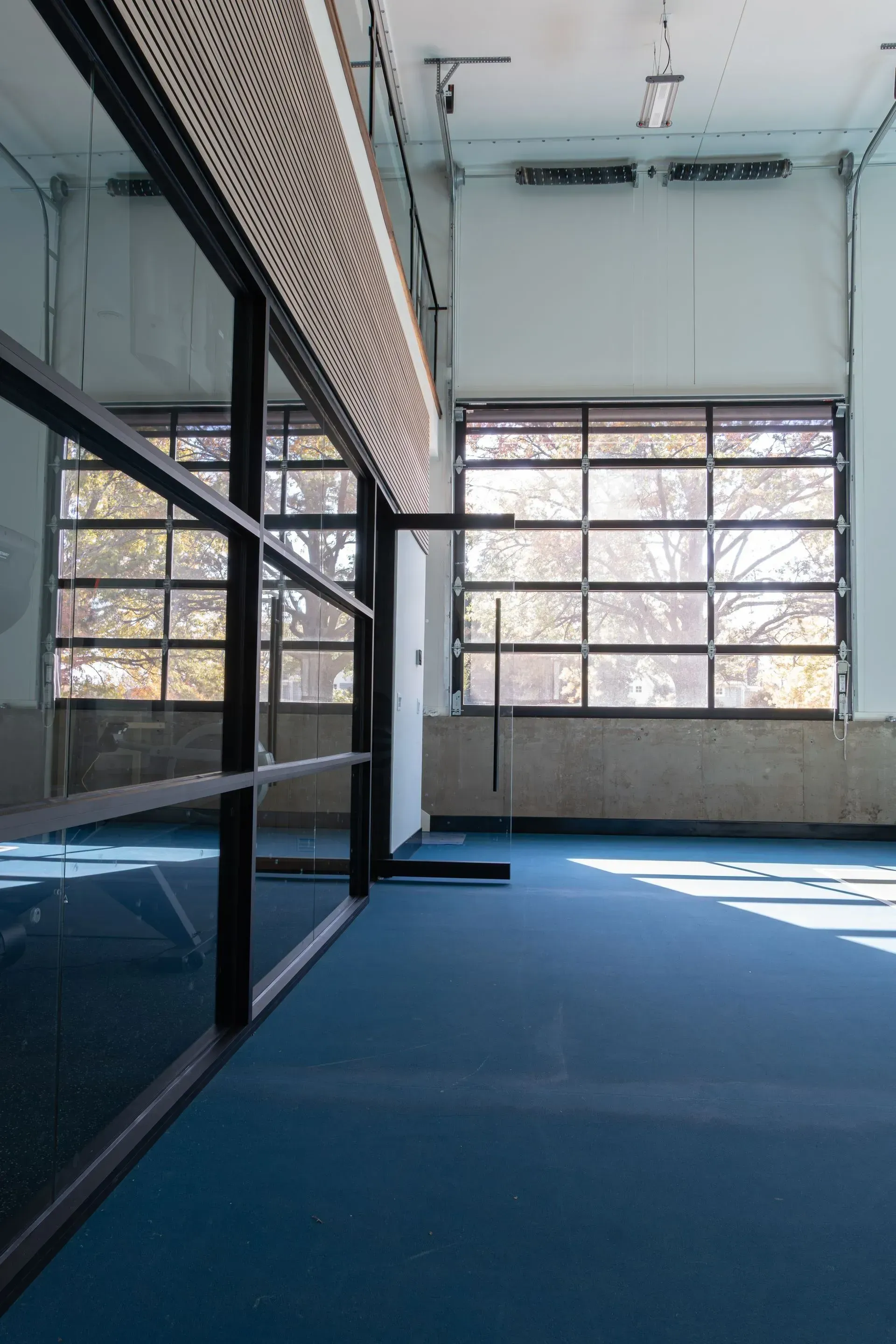 Blue-floored interior with large window; a black frame structure is on the left.
