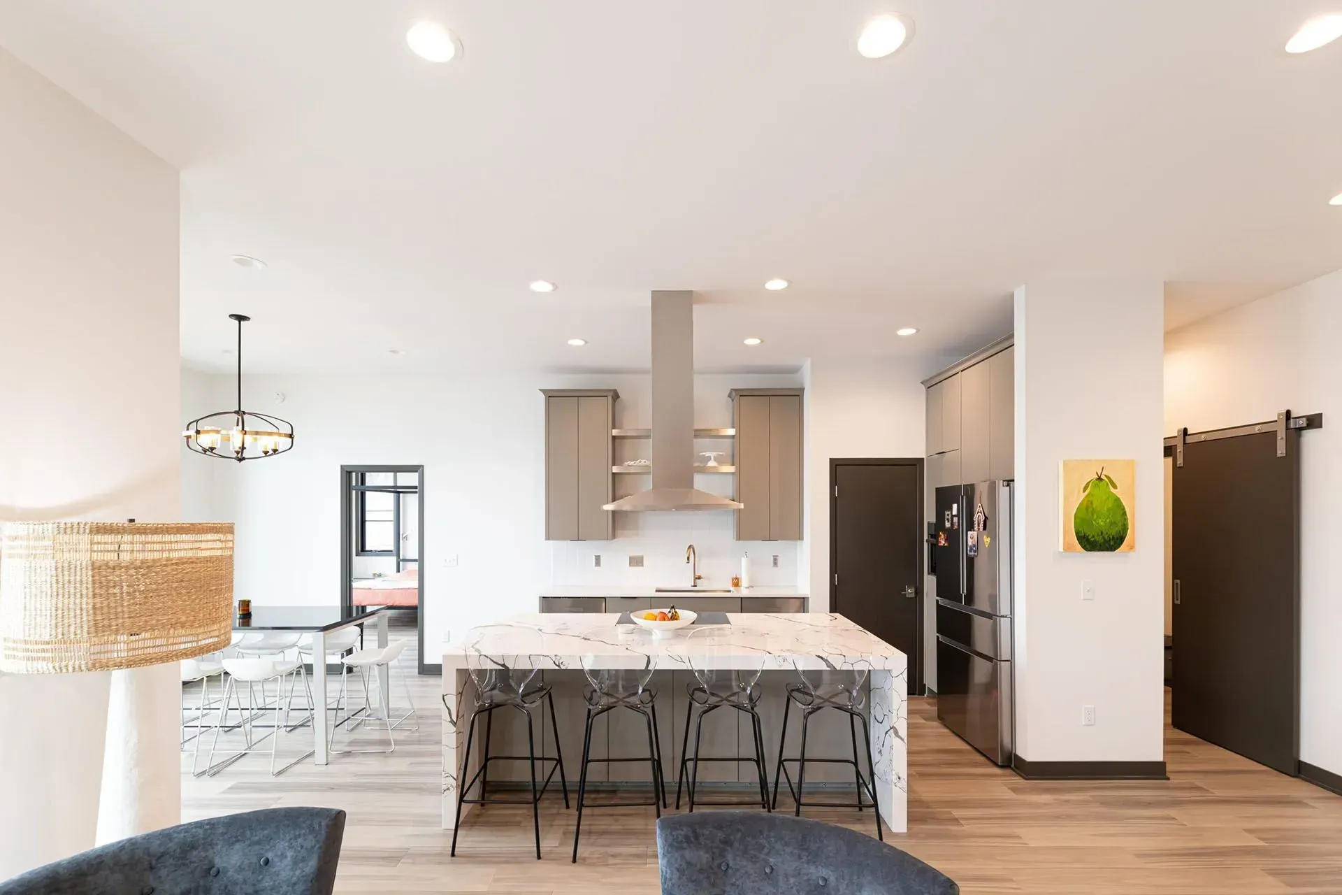 Modern kitchen with island, cabinets, stainless steel appliances, and adjacent dining area.