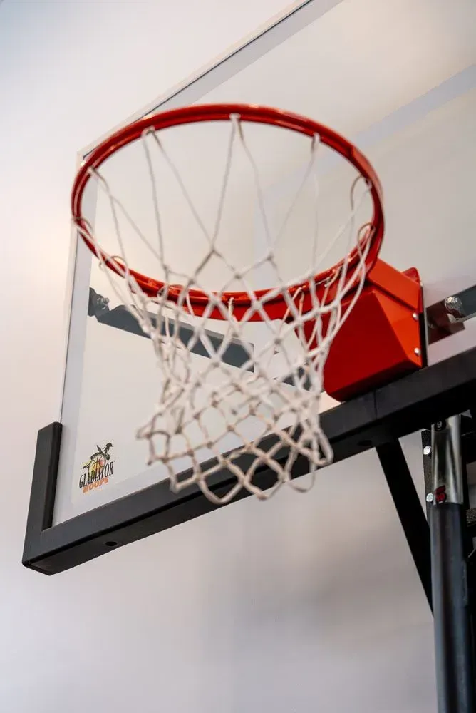 Basketball hoop with red rim and white net, mounted on black frame, against white wall.