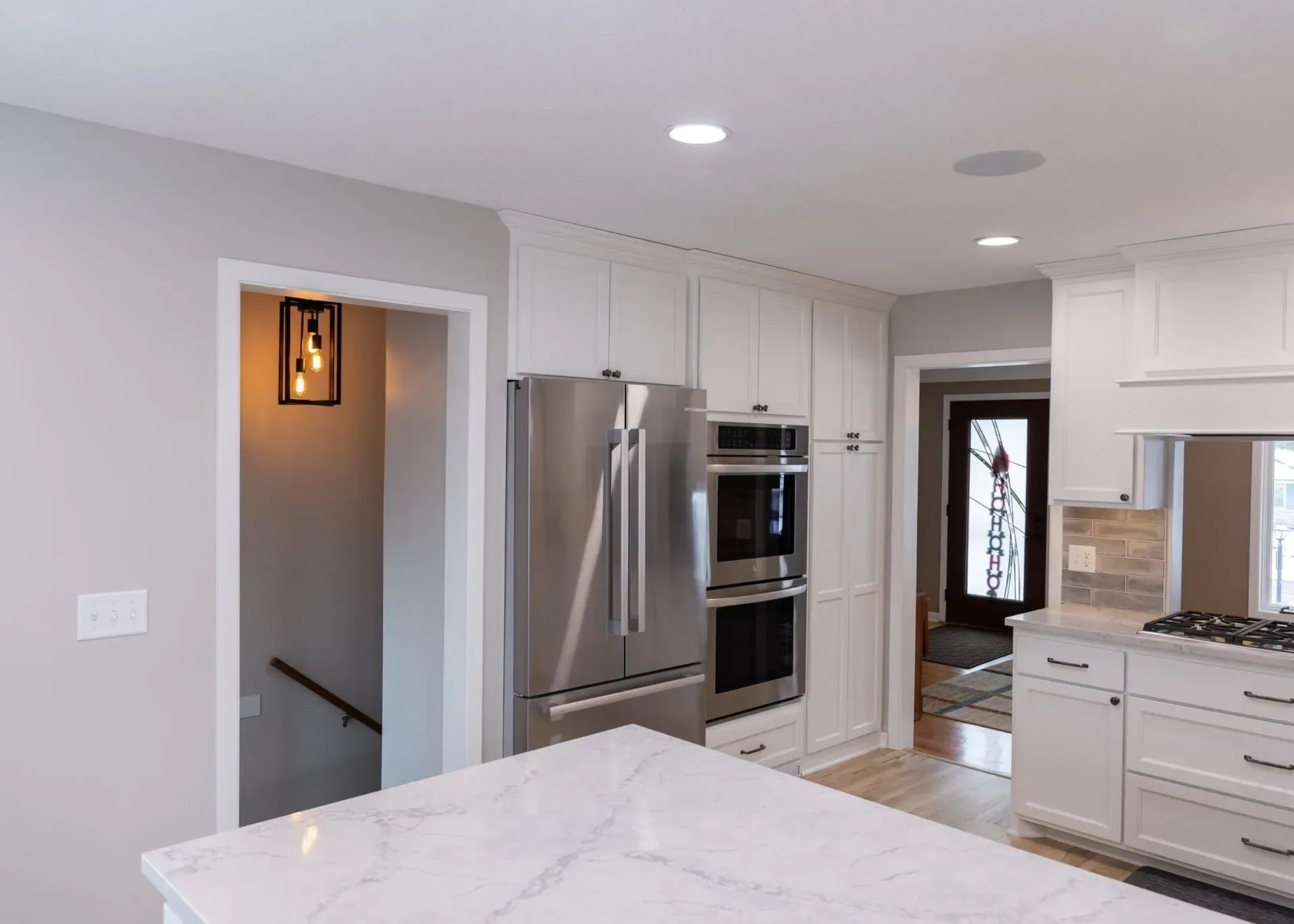 Kitchen with white cabinets, stainless steel appliances, and a marble countertop.