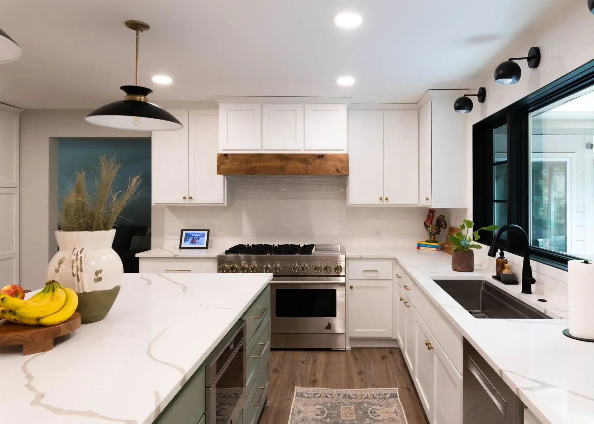 Modern kitchen with white cabinets, stainless steel appliances, and a green island.